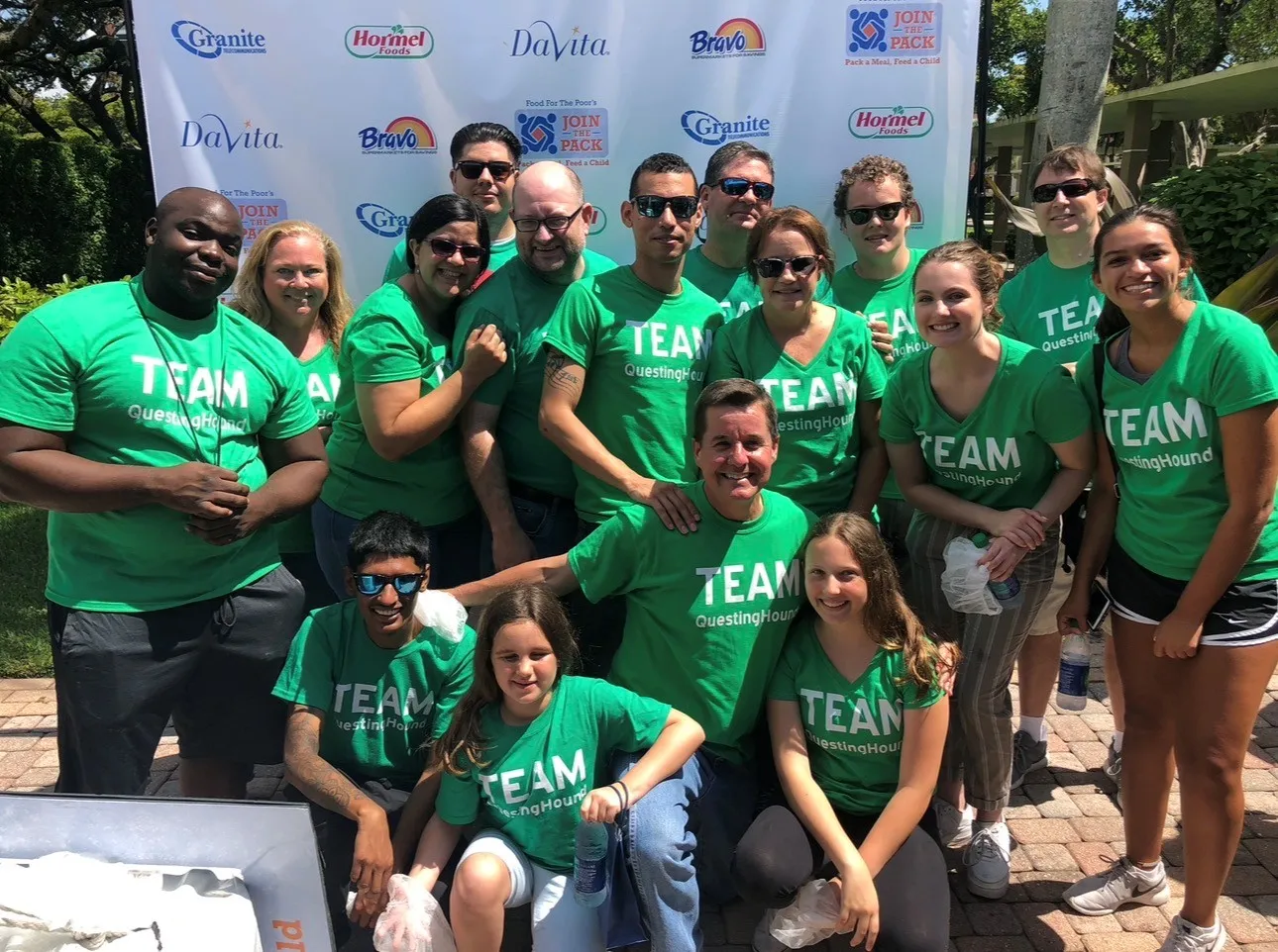 QuestingHound IT support team in matching green team shirts at a South Florida community event - the local Deerfield Beach team behind QuestingHound's managed IT services